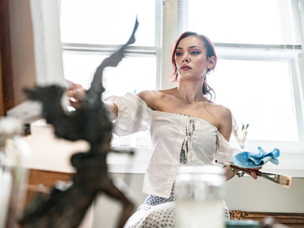 istock Young Caucasian woman painting in studio 1345523207