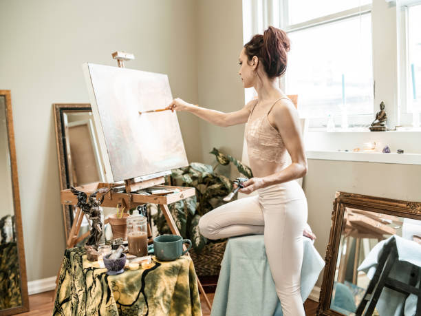 istock Young Caucasian woman painting in studio 1345523697