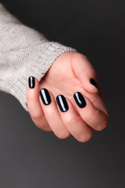 istock Female hand with black nails 1345526406