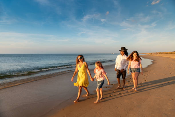 istock Family walking by the sea shore 1345528393