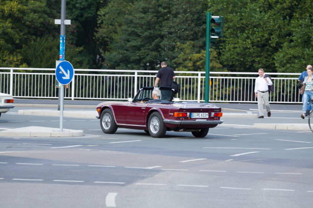 kaukasischer reifer mann fährt cabrio-oldtimer triumph - road trip collectors car sports car convertible stock-fotos und bilder