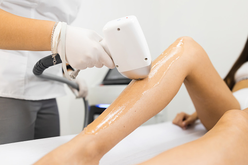 Proceso de depilación láser para las piernas de la mujer photo