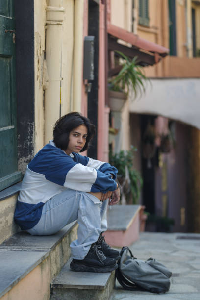 istock Teenage girl sitting on steps 1345531977