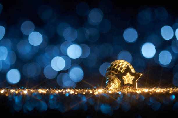 Funky blue Christmas - Background Star Defocused Gold Bokeh Still life photography of an abstract Christmas background. Moravian Star and Christmas ornament on golden shiny glitter, lens flares, and defocused blue lights. Native image size: 7952x5304 christmas star shape christmas lights blue stock pictures, royalty-free photos & images