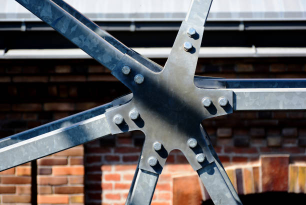 Bridge detail. galvanized steel truss joint and connection closeup with bolts. blurred soft brown brick wall background. selective focus. construction and architecture concept. brick arch and window. backdrop image.