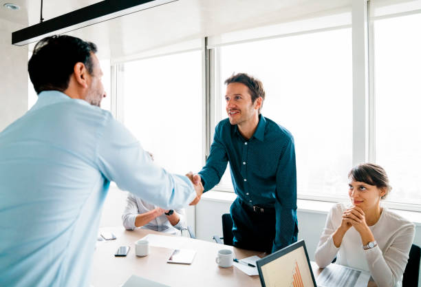 istock Two businessmen shaking hands in a meeting 1345535843