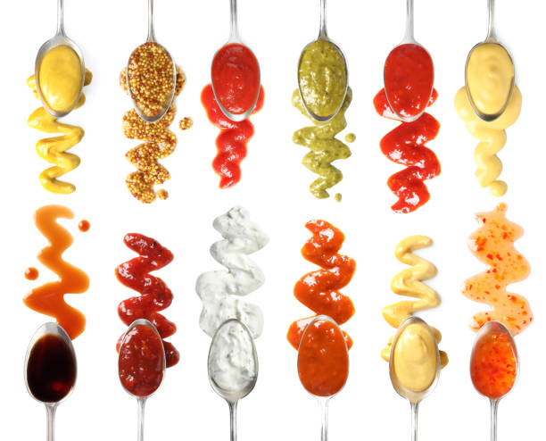 istock Set of spoons with different delicious sauces on white background, top view 1345536989