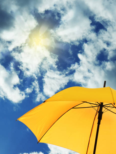 istock Modern yellow umbrella against blue sky, space for text. Sun protection 1345538745