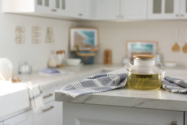 istock Teapot and towel on white marble table in modern kitchen. Interior design 1345539785