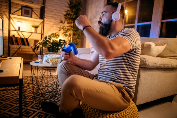 istock Young ethnic man playing video games 1345540014
