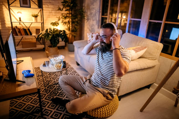 istock Young ethnic man playing video games 1345540024