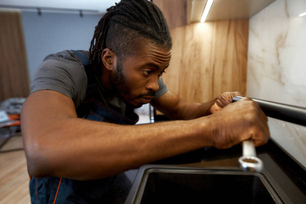 istock Professional plumber fixing water tap in kitchen, close view 1345540099