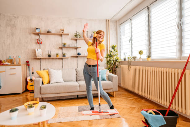 alegremente mujer limpiando casa y cantando - dust dusting cleaning broom fotografías e imágenes de stock