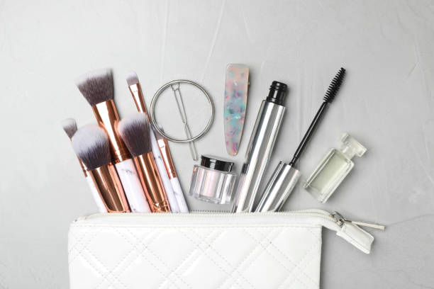 istock Cosmetic bag with makeup products and beauty accessories on light grey background, flat lay 1345541148