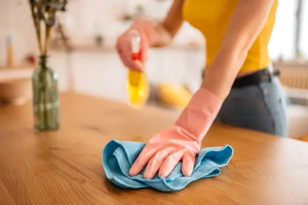 Photo of Woman wiping the dining table surface