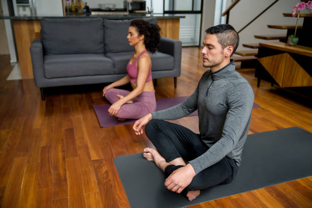 istock Man meditating at home with his coach 1345541570