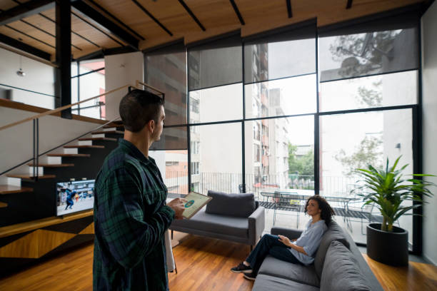 Happy Latin American couple controlling the settings of their smart home using a tablet computer - technology concepts. **PHOTO ON SCREEN BELONGS TO US**