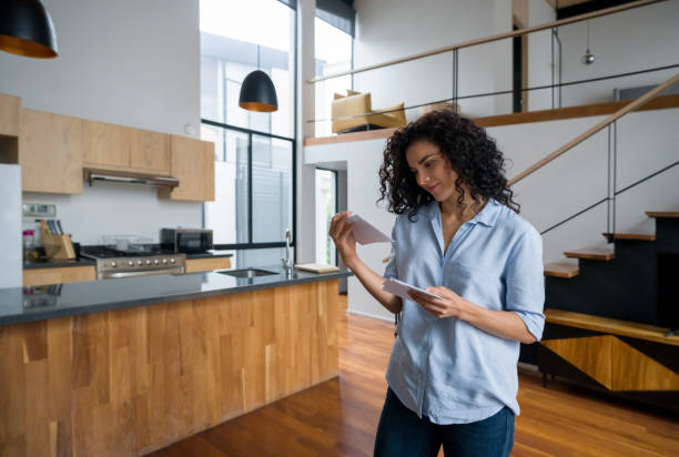 Happy woman at home checking letters in the mail Portrait of a happy Latin American woman at home checking letters in the mail and smiling - domestic life concepts mail stock pictures, royalty-free photos & images