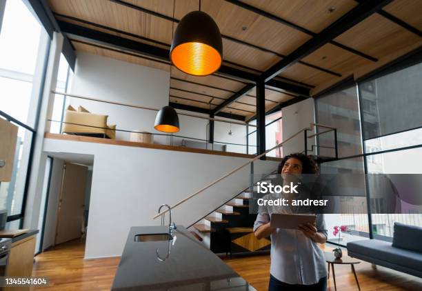 Woman Controlling The Lights Of Her House Using A Home Automation System Stock Photo - Download Image Now