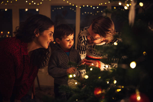 istock Boy decorating Christmas tree with parents 1345541716