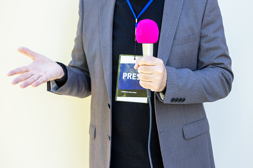 Broadcast journalist gesturing during media interview