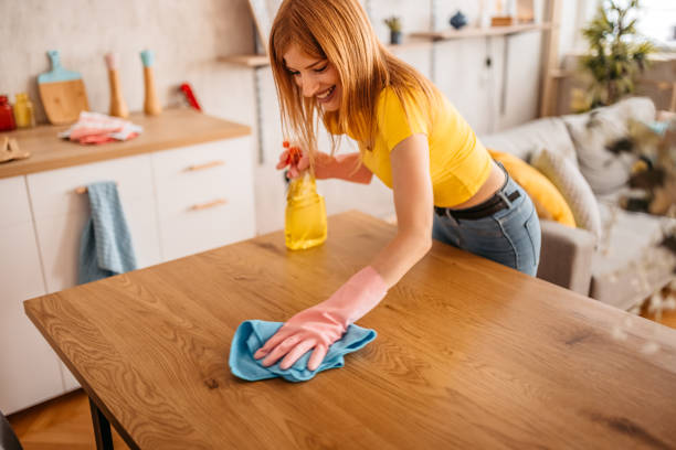 istock Woman wiping the dining table surface 1345541740