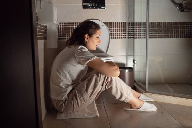Young woman sitting near toilet Young woman sitting near toilet, poisoning, toxicosis. food poisoning stock pictures, royalty-free photos & images