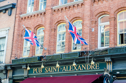Two English flags above St. Alexandre pub in Old Quebec during day of autumn
