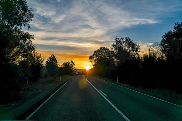 istock Road through Australia's countryside with setting sun. 1345545682