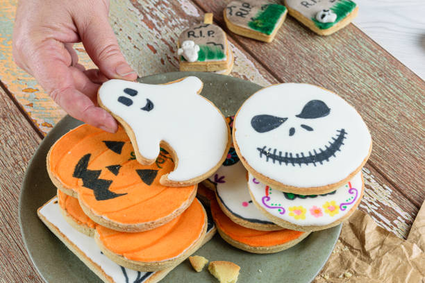 istock Female hand catching a Halloween themed buttery cookie. 1345546514