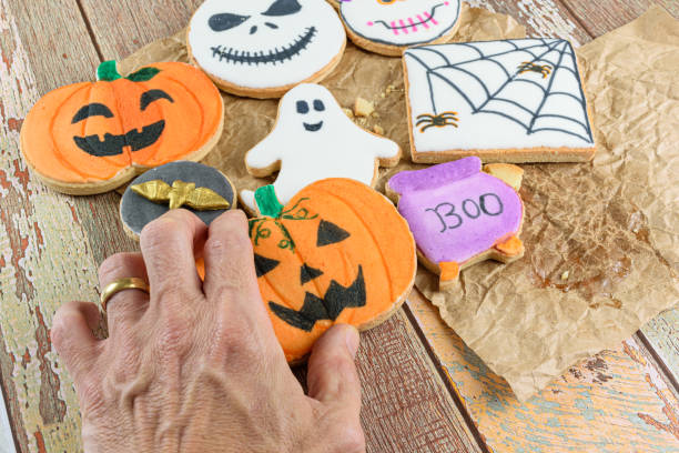Male hand catching a pumpkin-shaped buttery biscuit.