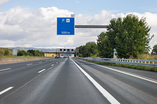 A blue road sign showing the direction to Budapest over a asphalted road, Hungary