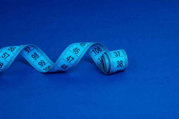 istock Colorful spiral tape measure on color background with space for text 1345549812