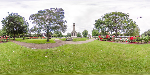 Great Yarmouth, Norfolk, UK – July 12 2021. Full spherical seamless panorama 360 degrees angle view of the War memorial in the public park in the seaside town of Great Yarmouth. This is an equirectangular projection that can be used for virtual reality (VR) content and similar immersive uses.