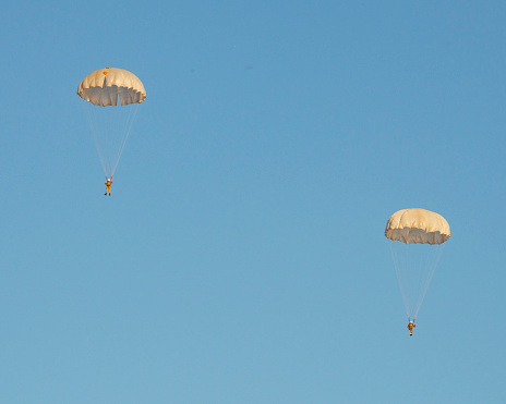 Skydiver with open chute at the blue sky on sunny day