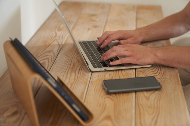 istock Close-up of a man's hands typing on a keyboard, looking for information. A freelance copywriter is working on a project. The concept of remote work 1345552454