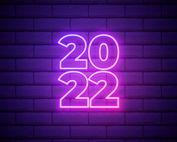 istock 2022 neon signboard. Happy New Year. Realistic pink neon numbers on dark brick wall. Vector 2022 in neon linear style. 1345553550