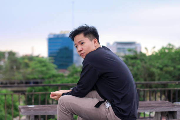 istock Young men sitting enjoying at city park 1345554688