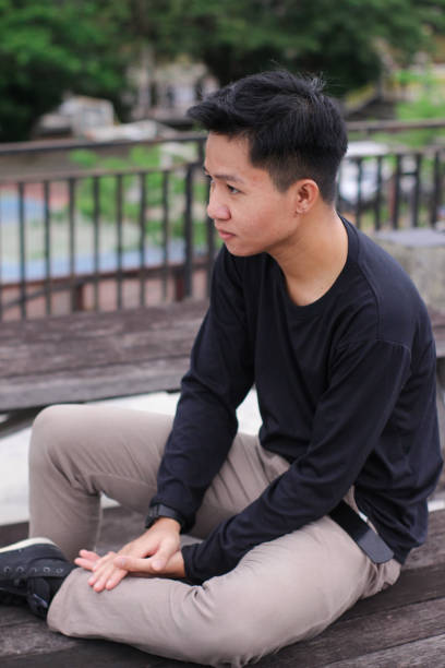 istock Young men sitting enjoying at city park 1345554841