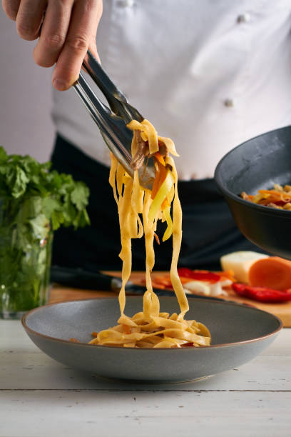 istock a chef puts noodles on a plate tsuivan traditional mongolian dish with meat vegetables homemade pasta 1345555873