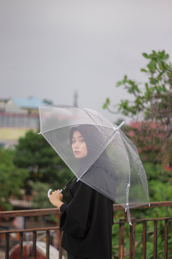 Asian women standing with an umbrella in a city park