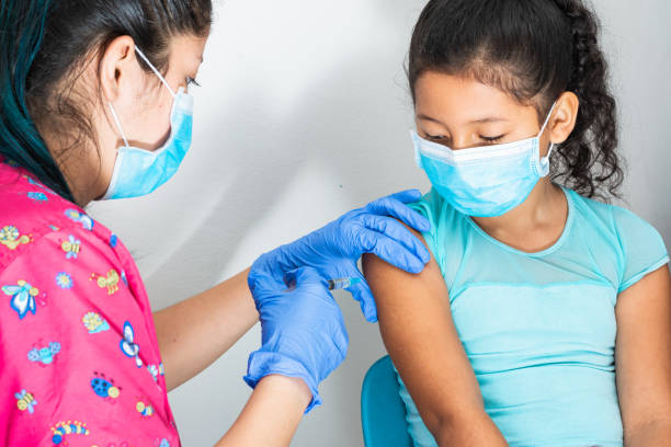 children's nurse injecting brown girl's arm. (8 year old girl), doctor's hands with rubber gloves injecting covid-19 vaccine. flu vaccine. medical concept, health and pandemic. children's nurse injecting brown girl's arm. (8 year old girl), doctor's hands with rubber gloves injecting covid-19 vaccine. flu vaccine. medical concept, health and pandemic. injecting flu virus vaccination child stock pictures, royalty-free photos & images