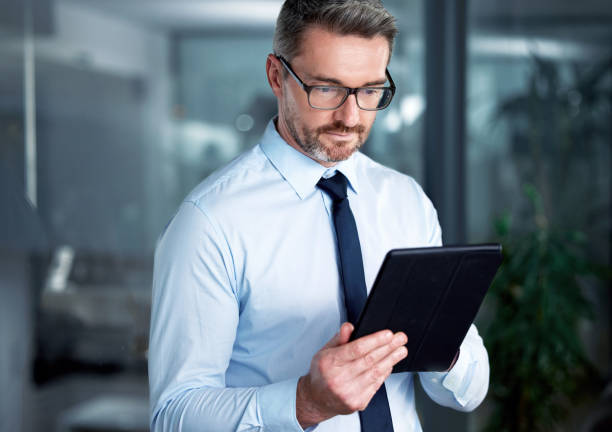 istock Shot of a businessman using a digital tablet at the office 1345558524