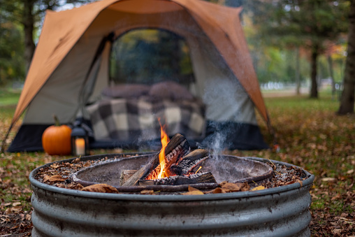 Fall campsite with campfire and orange tent