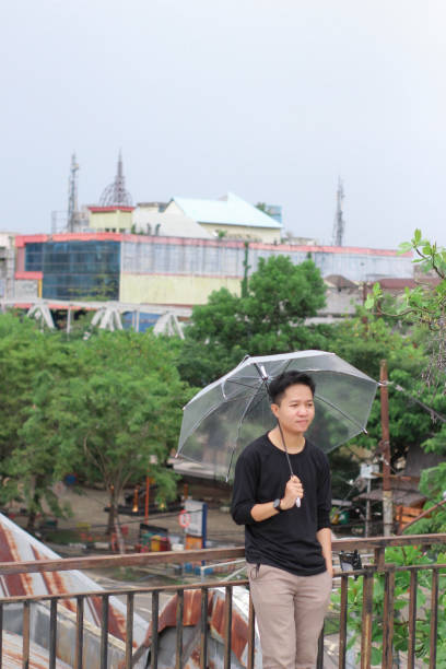 young men lonely with an umbrella in a city park - umbrella men business businessman imagens e fotografias de stock