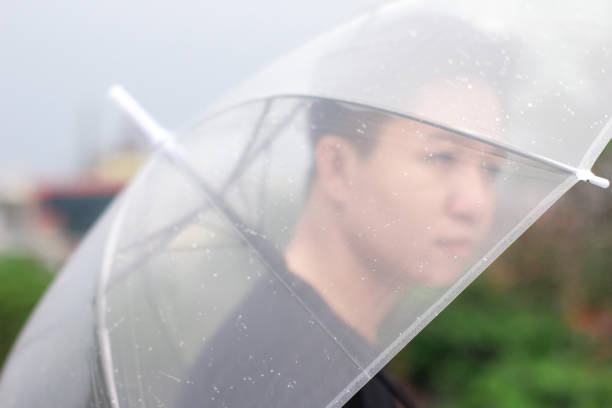 jóvenes con un paraguas en un parque de la ciudad - umbrella men business businessman fotografías e imágenes de stock