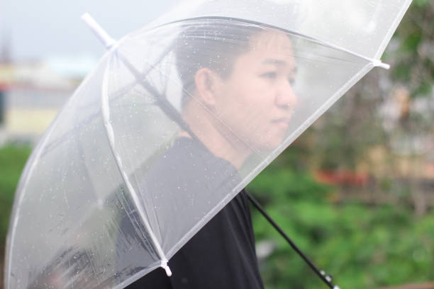 jóvenes con un paraguas en un parque de la ciudad - umbrella men business businessman fotografías e imágenes de stock