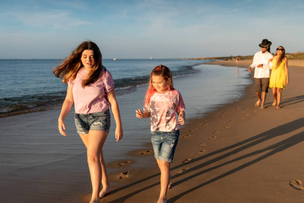 istock Family walking by the sea shore 1345559690