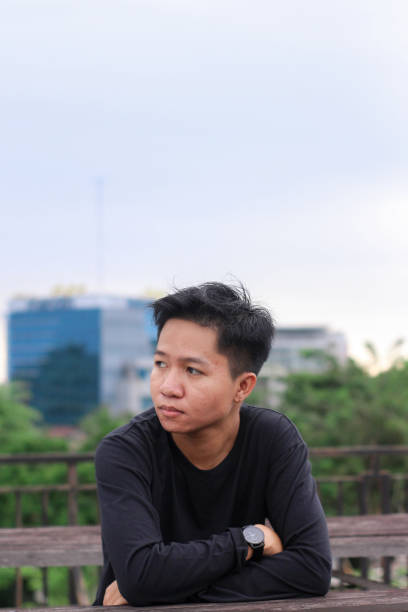 istock Young men sitting waiting enjoying at city park 1345559916