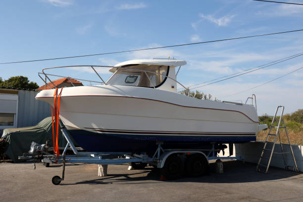 istock White boat with a motor on a car trailer 1345560044